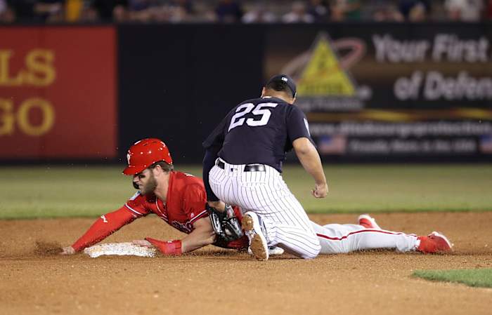 Bryce Harper sliding past Gleyber Torres